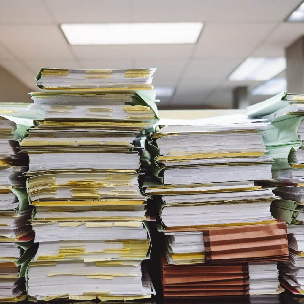 stacks of books and papers on a table